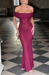 Woman wearing a burgundy lace off-shoulder dress on a checkered floor.