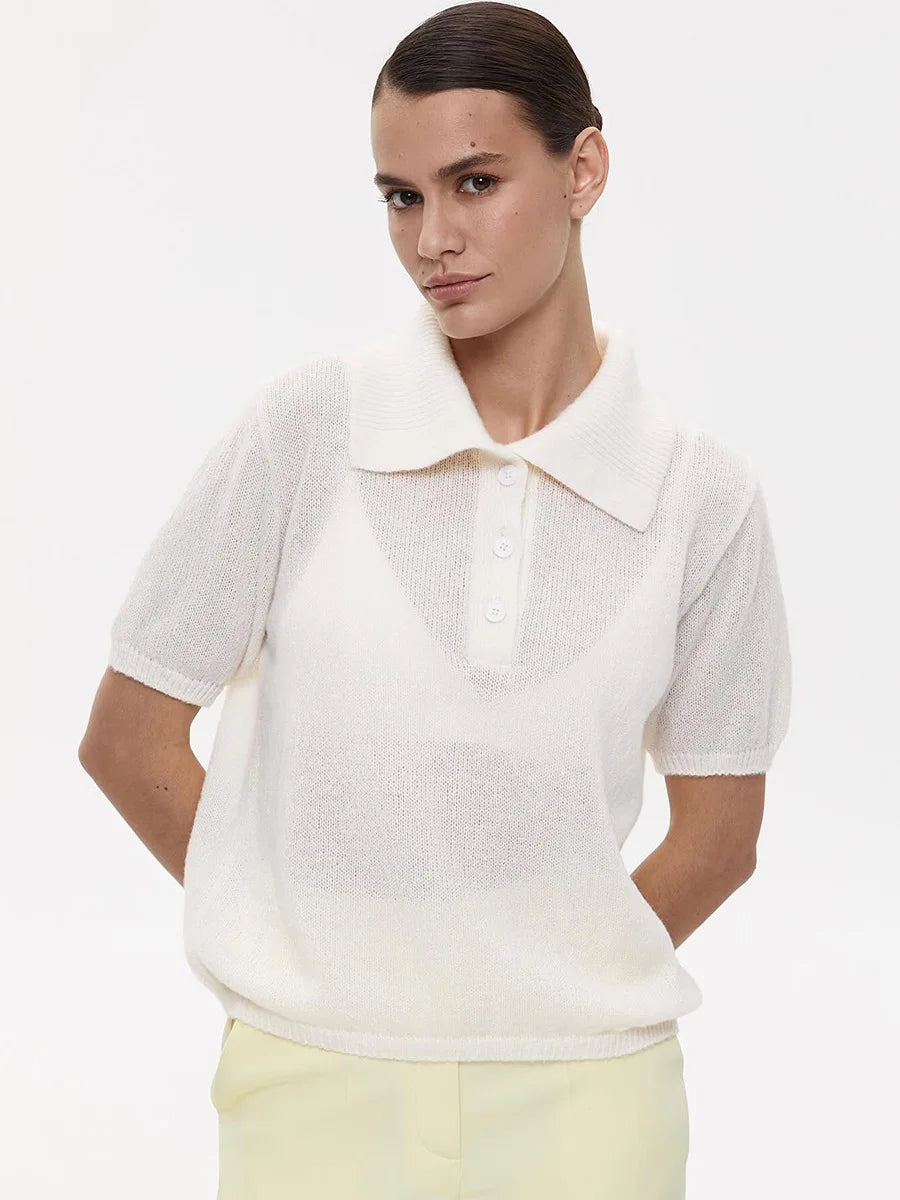 Woman wearing a white short-sleeve shirt with a collar on a plain background
