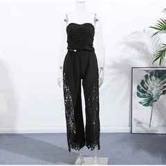 Black lace strapless top and pants on a mannequin against a white wall with a plant in the corner.