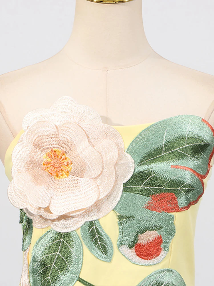 Mannequin wearing a dress with floral embroidery on a white background