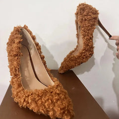 Textured pointed toe stiletto heels being held