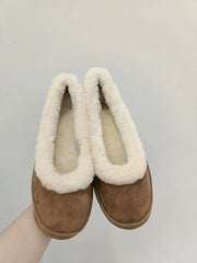 Pair of fleece lined slip on loafers held in hand
