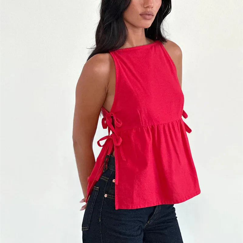 Woman wearing a red sleeveless top with tie details on a white background