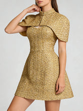 Gold dress with cape detail worn by a model on a white background