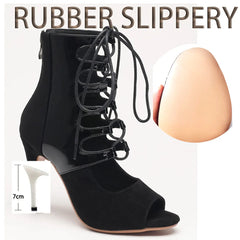 Black high-heeled shoe with lace-up design next to a measuring stick and an egg for scale on a white background.