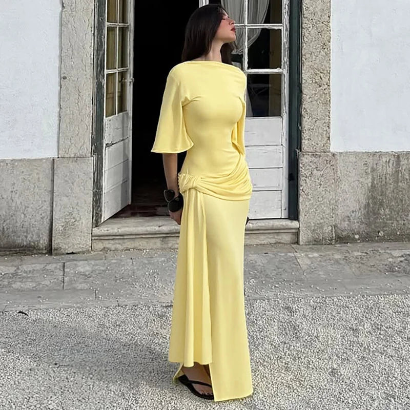 Woman in a yellow dress standing outside a building