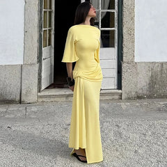 Woman in a yellow dress standing outside a building