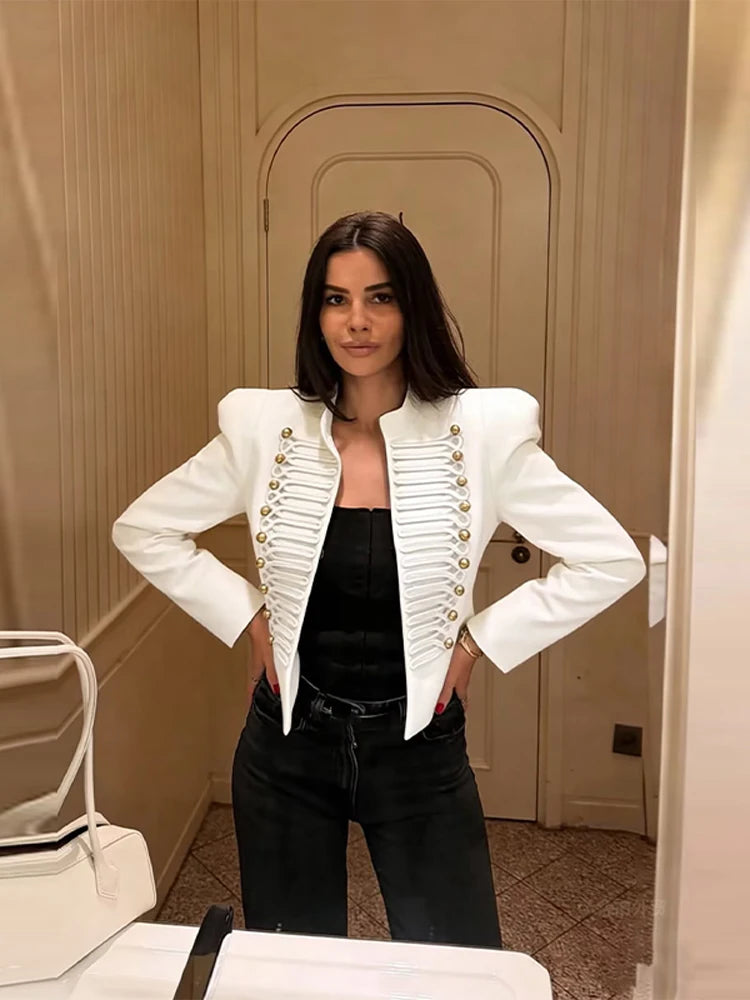 Woman wearing a white cropped military style jacket with gold buttons and cord braiding
