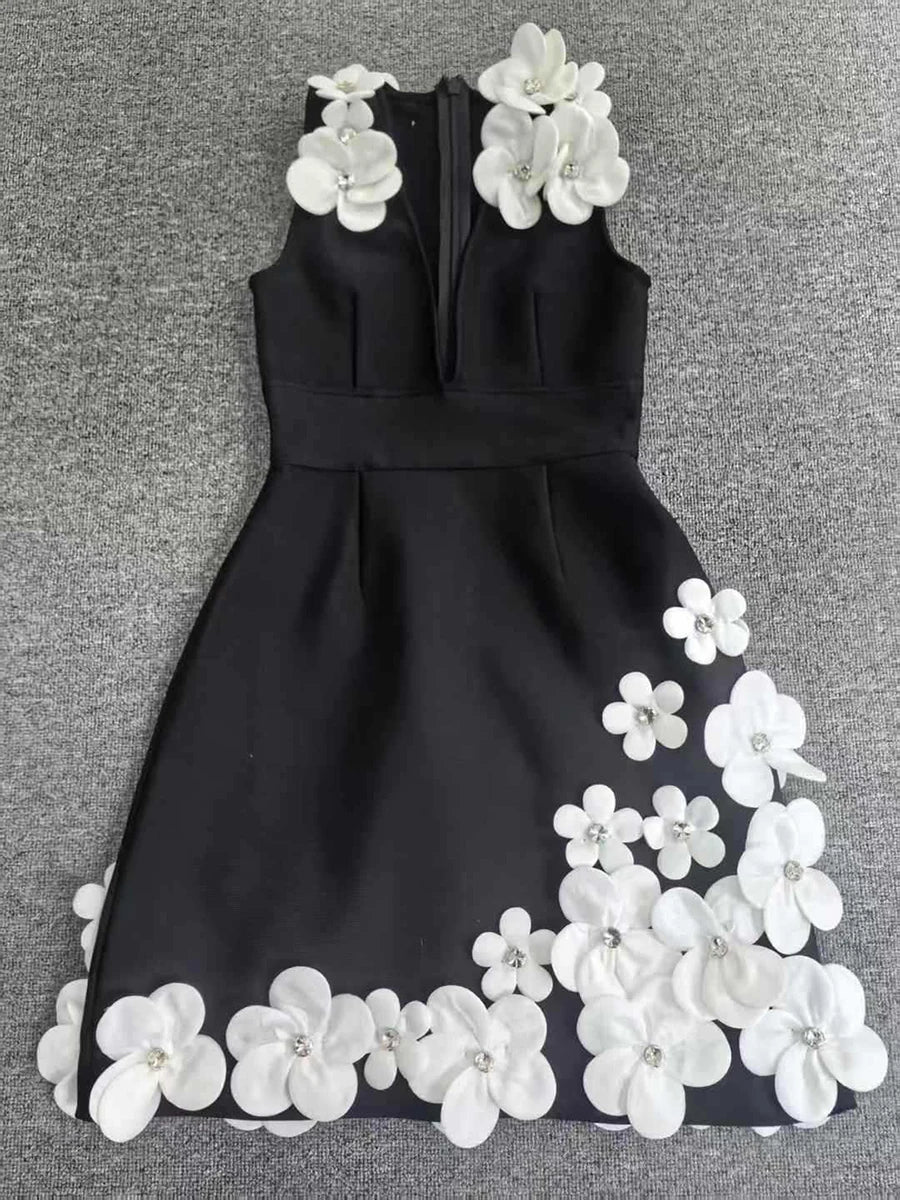 Black dress with white floral embellishments on a gray background