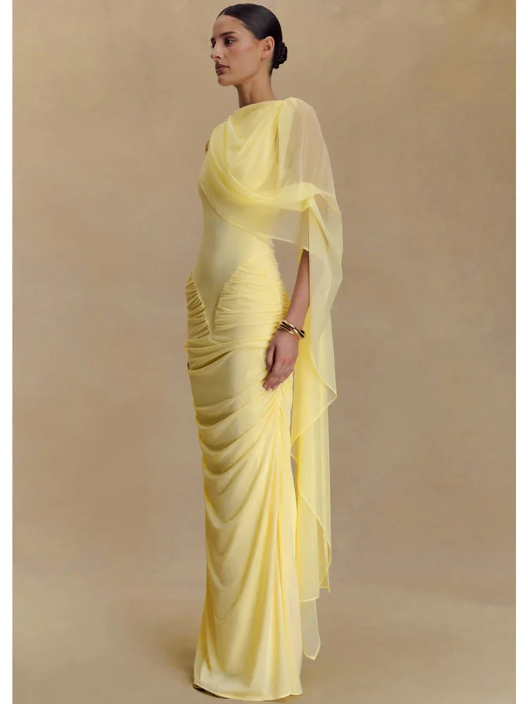 Woman wearing a yellow saree with a plain background