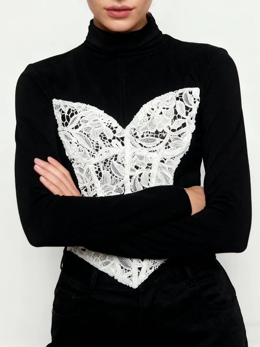 Black turtleneck sweater with a white lace butterfly design on a plain background