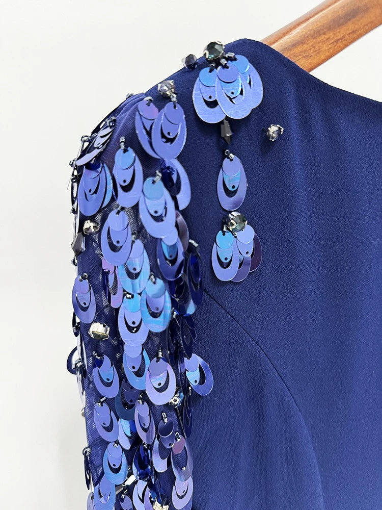 Navy blue garment with decorative blue sequins on a white background