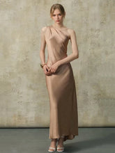 Woman wearing a one-shoulder maxi dress with a draped neckline and floor-length hem