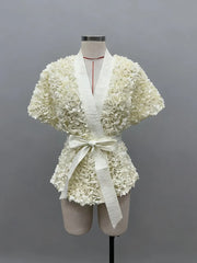 White floral dress on a mannequin against a gray background