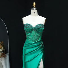 Green evening gown with beaded bodice on a mannequin against a black background