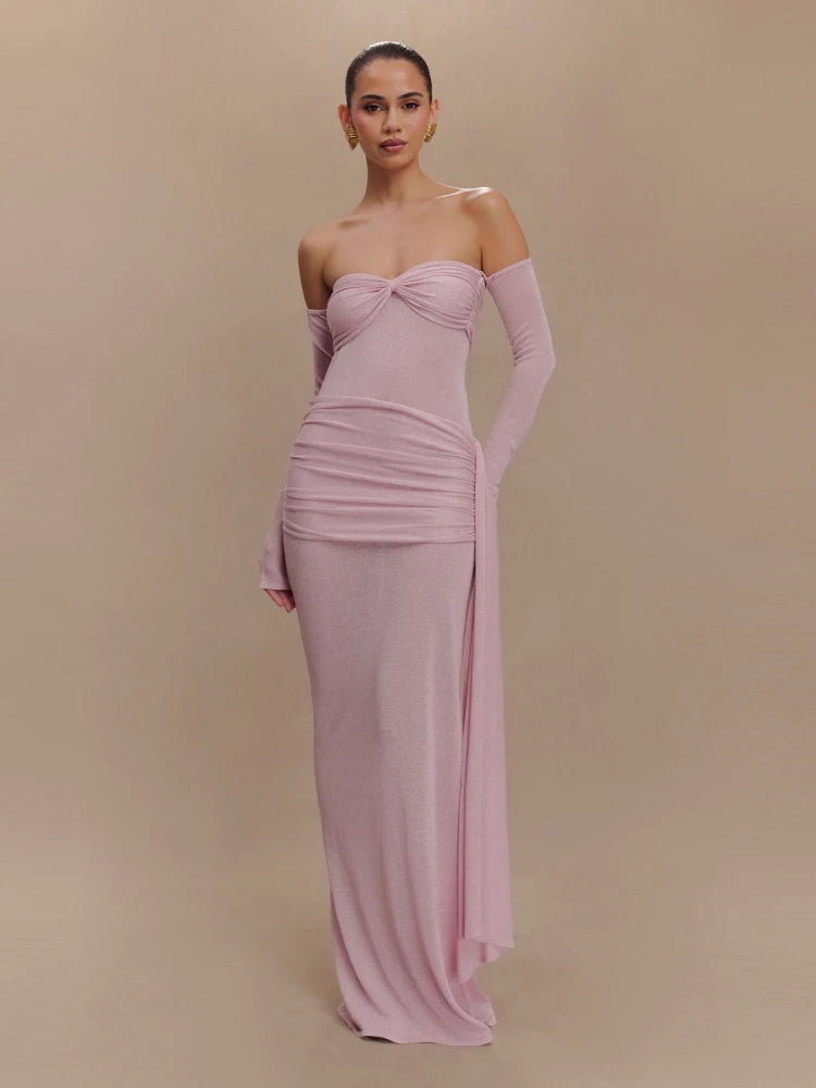 Woman wearing a pink strapless gown with matching gloves on a beige background