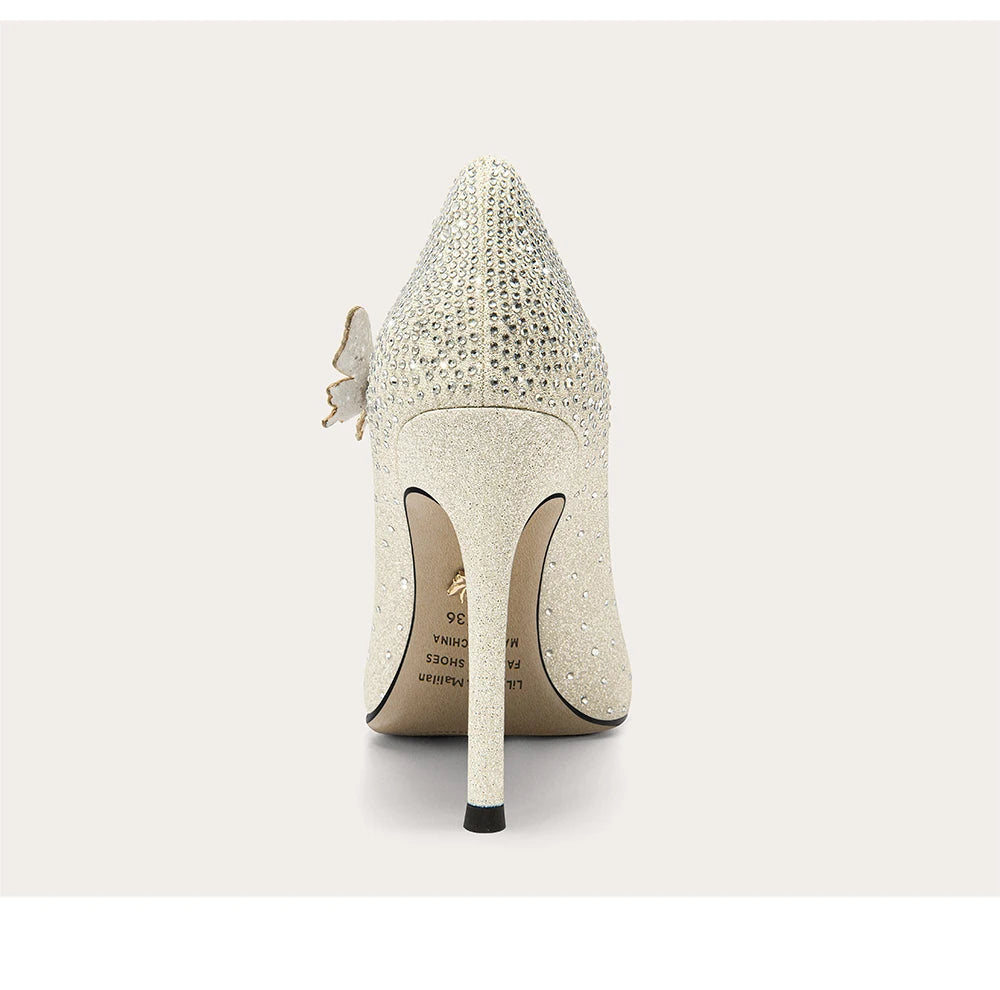 White high-heeled shoe with crystal embellishments on a light gray background
