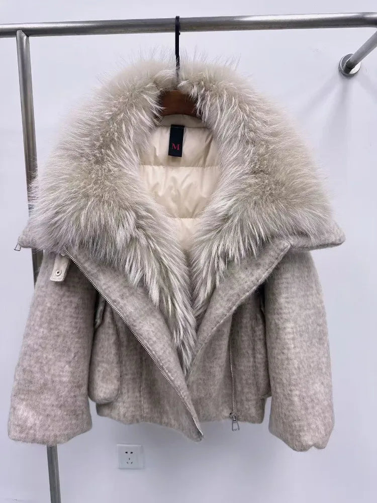 Beige winter coat with fur hood on a rack against a white wall.