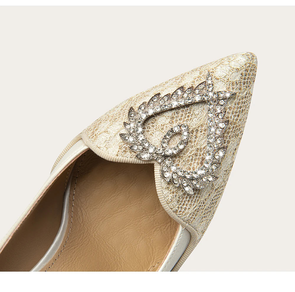 Gold high-heeled shoe with decorative embellishments on a light background