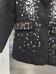Black blazer with gold and silver embellishments on a blurred background
