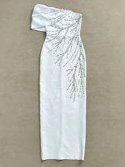 White one-shoulder dress with beading on a beige background
