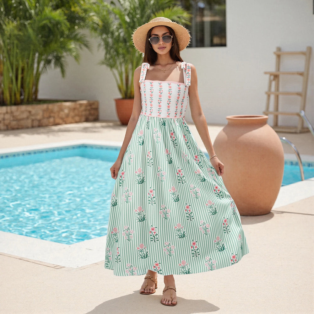 Woman wearing floral and striped maxi dress by a poolside