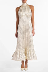 White halter neck dress with black polka dots on a white background