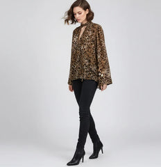 Woman wearing a leopard print blouse and black pants on a white background