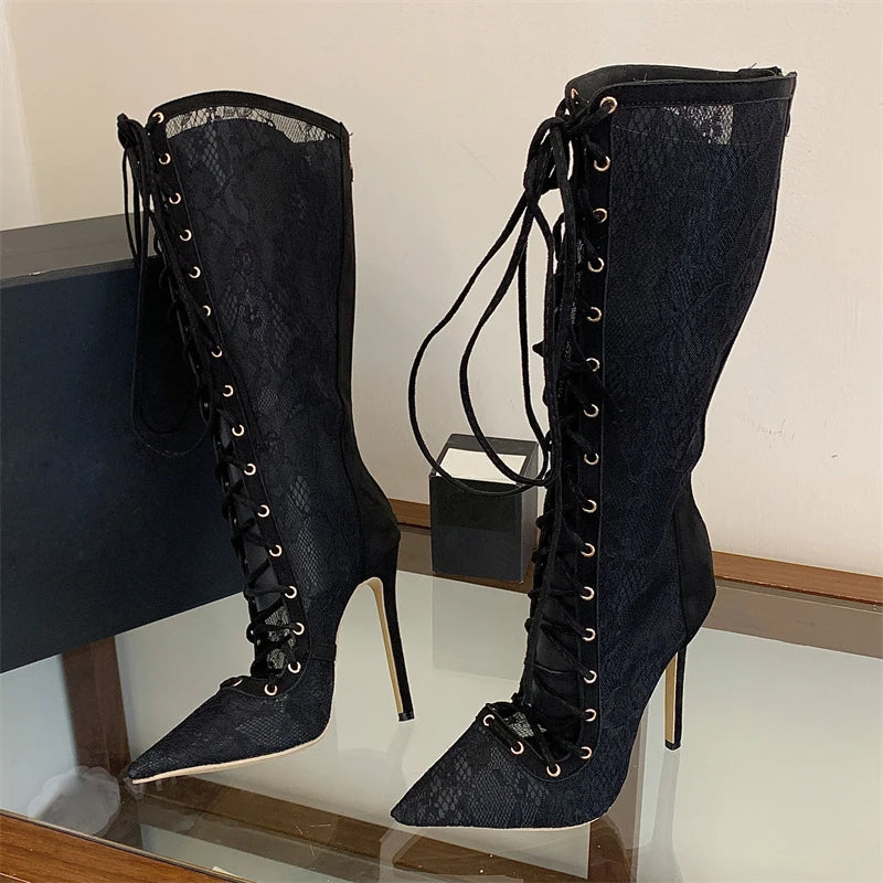 Pair of lace-up knee-high boots on a glass surface