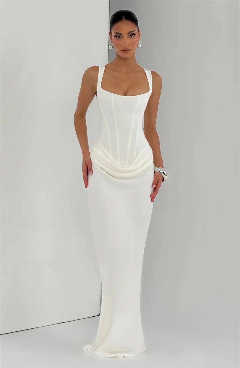 Woman wearing a white evening gown against a plain background