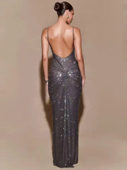 Woman wearing a sparkly silver evening gown with a plain background