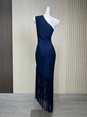 Navy blue dress with fringe details on a mannequin against a striped wall.