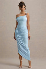 Woman wearing a light blue one-shoulder dress against a beige background