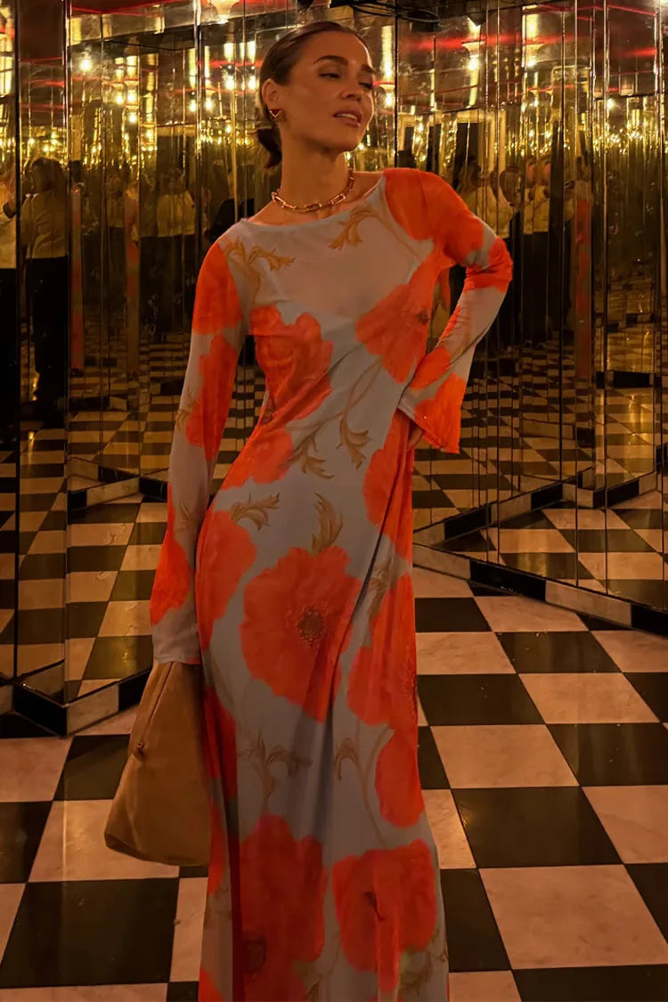 Woman in a floral dress standing in a reflective, mirrored room with black and white checkered floor.