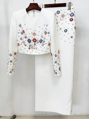 White embellished cropped top and maxi skirt hanging on a rack