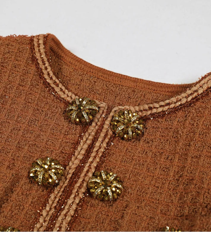 Brown textured fabric with gold buttons on a plain background