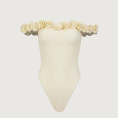 Cream one piece swimsuit with off-shoulder rose trim displayed on a mannequin.