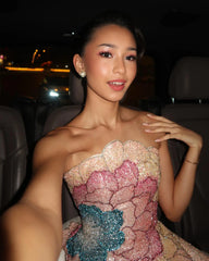Woman in a sparkling dress inside a vehicle at night.