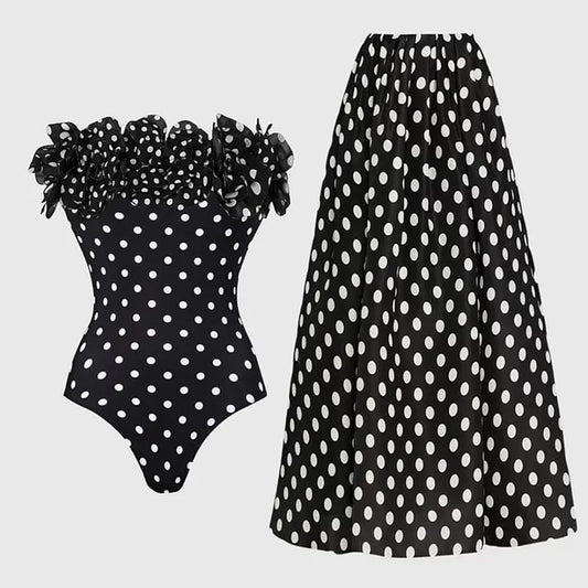 Off-the-shoulder ruffled polka dot one-piece swimsuit and maxi skirt set laid flat.