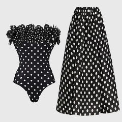 Off-the-shoulder ruffled polka dot one-piece swimsuit and maxi skirt set laid flat.