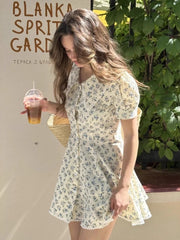 Woman in a floral dress holding a drink, with 'Blanka Spirit Garden' branding in the background.