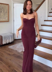 Woman in a burgundy dress standing in a home interior.