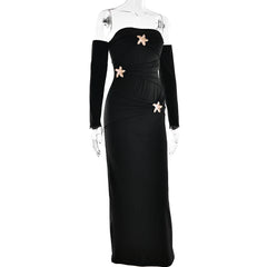 Black evening gown with gold embellishments on a mannequin against a white background