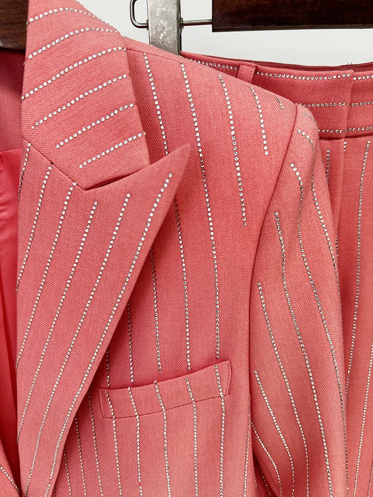 Close-up of a pink pinstripe suit jacket with a wooden hanger in the background.