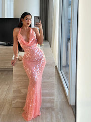 Woman in a pink sequin dress taking a mirror selfie in a modern interior setting.