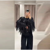 Person wearing a black sequin fringe top in a mirror selfie.