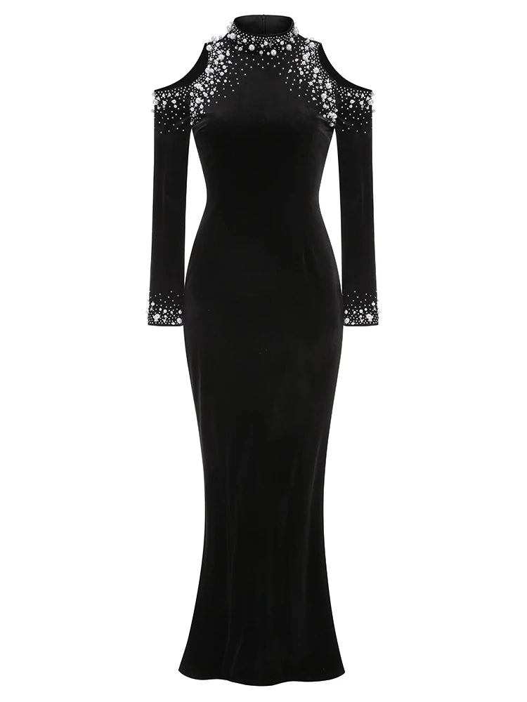 Black evening gown with sheer sleeves and embellishments on a white background