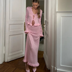 Woman in a pink outfit standing in a doorway.