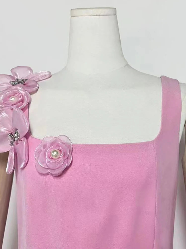 Pink dress with floral embellishments on a mannequin against a white background
