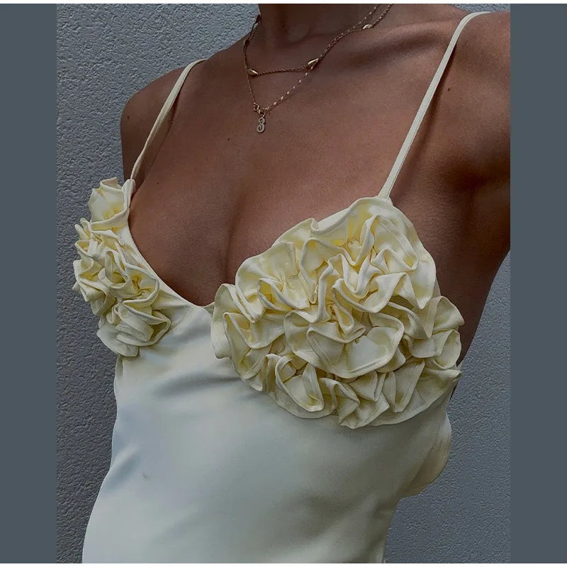 White floral top worn by a person against a gray background